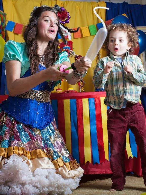 A San Jose faerie twisting a balloon for an excited child