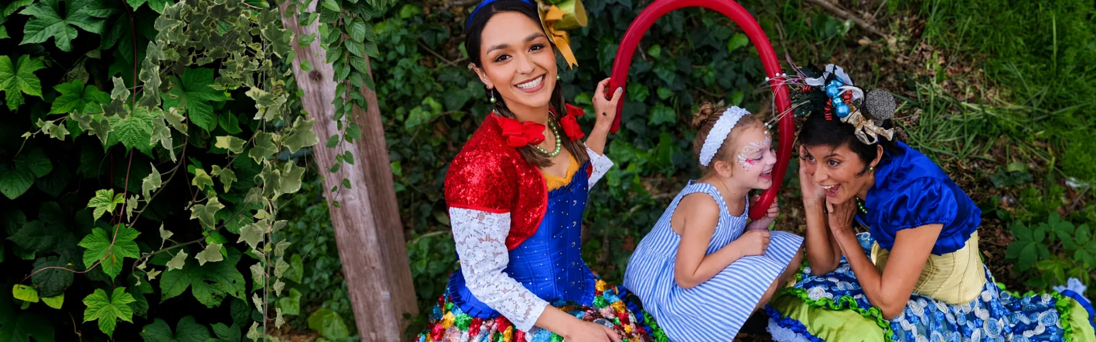 A Happily Ever Laughter performer teaching a child how to twist a balloon.