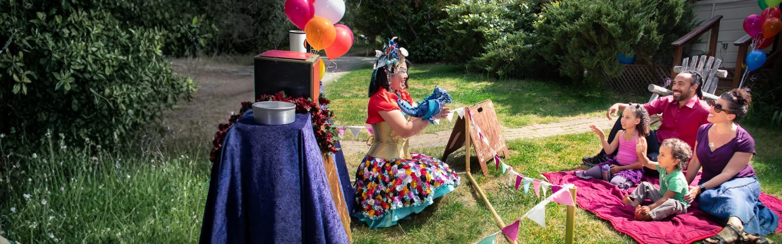 Costumed performers leading games and crafts at a children's birthday party outdoors.