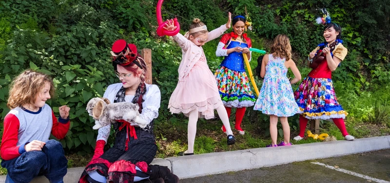 A performer leading a group of children at a busy community event.