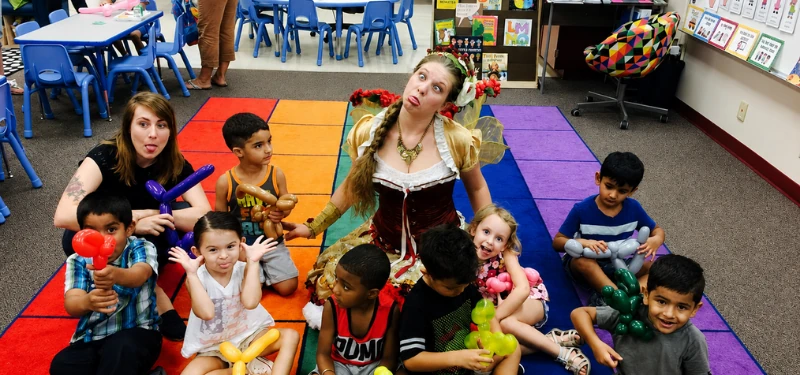 A performer leading a group of delighted children in an activity at a school event.