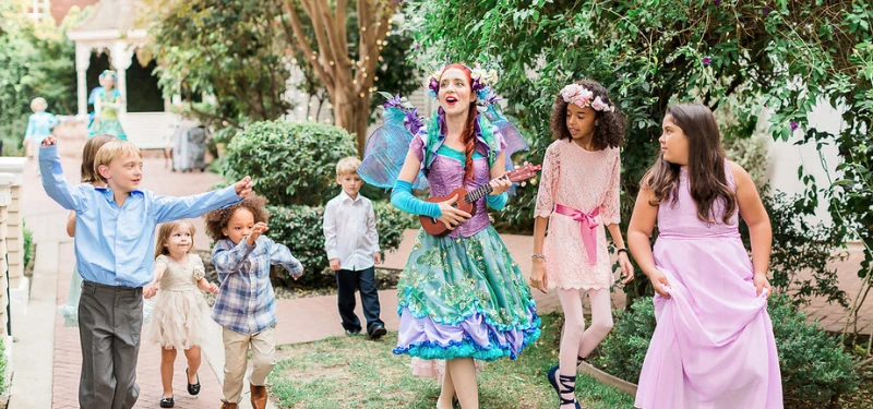 A performer delighting a group of children at a wedding.