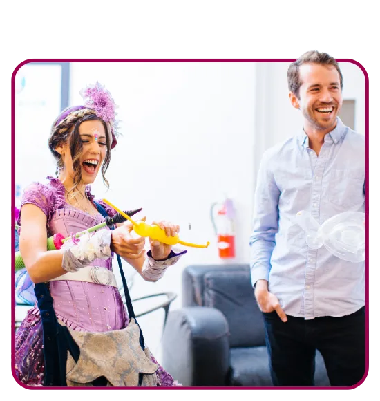 A Happily Ever Laughter balloon twister roaming an outdoor party handing balloon animals to children.